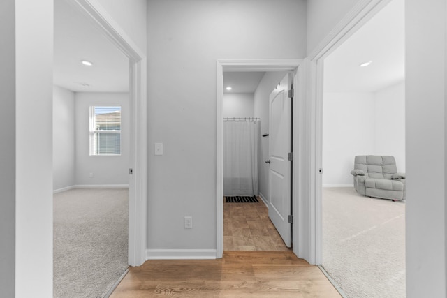 hall with light colored carpet