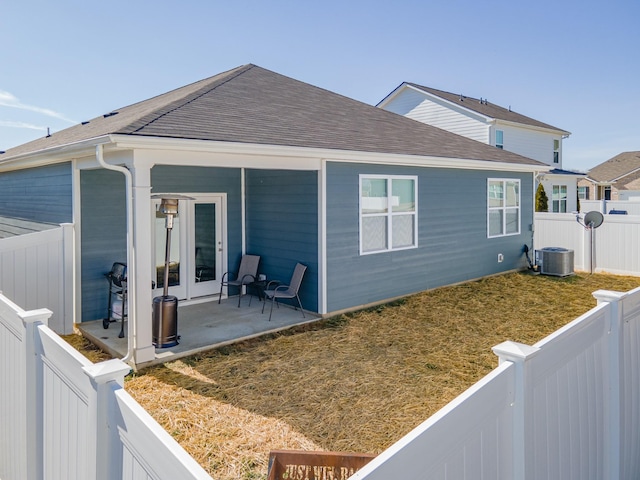 rear view of property with cooling unit, a yard, a patio area, and french doors