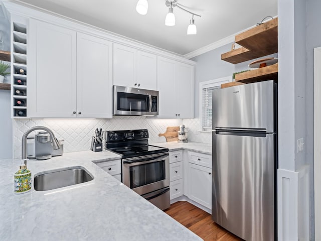 kitchen featuring stainless steel appliances, sink, white cabinets, and decorative backsplash