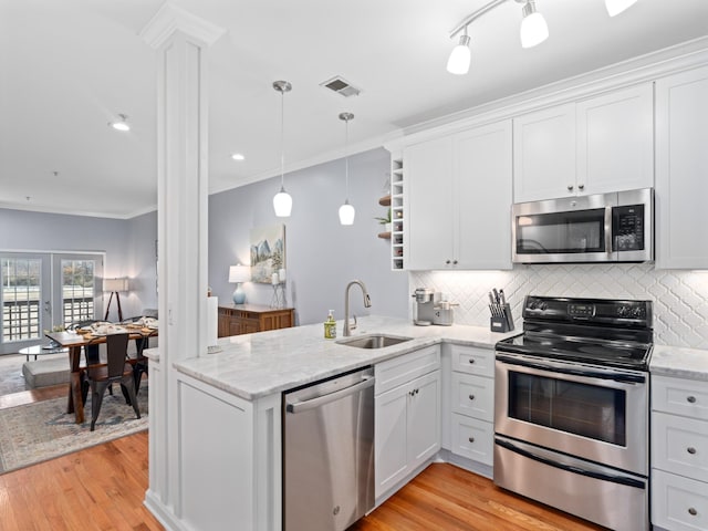 kitchen with kitchen peninsula, white cabinets, and appliances with stainless steel finishes