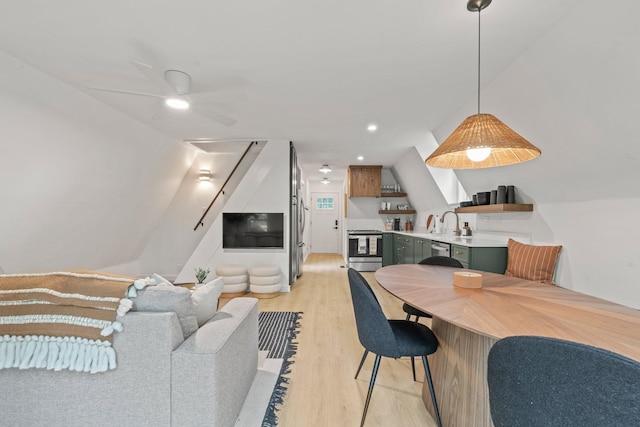 living room with ceiling fan, lofted ceiling, sink, and light wood-type flooring