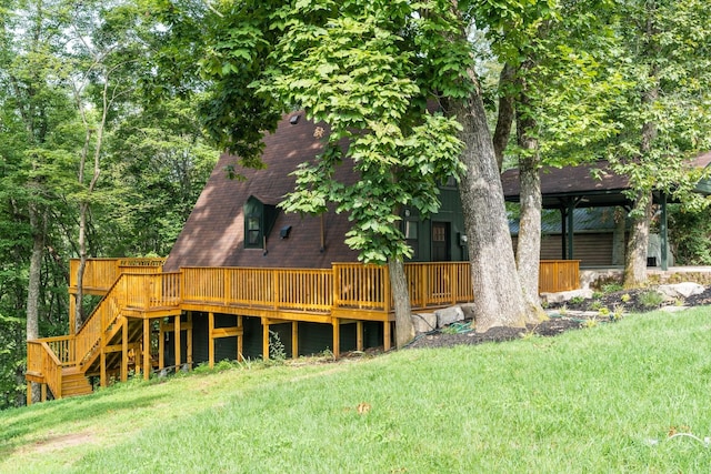 back of property featuring a wooden deck and a lawn