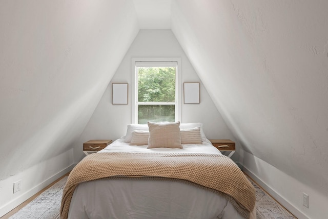 bedroom featuring hardwood / wood-style floors and vaulted ceiling