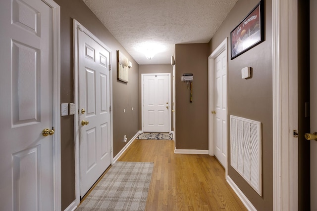 doorway featuring a textured ceiling and light wood-type flooring