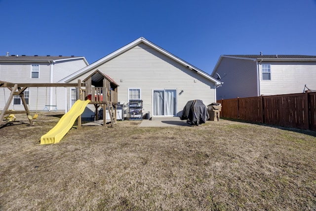 rear view of house with a yard and a playground