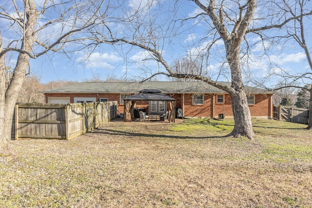 rear view of property featuring a gazebo and a lawn