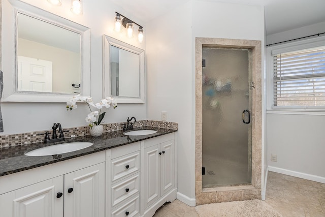 bathroom with an enclosed shower, vanity, and decorative backsplash