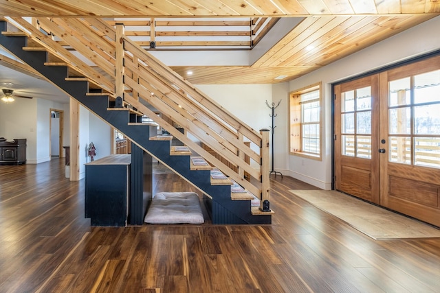 entrance foyer featuring a wood stove, french doors, wooden ceiling, and dark hardwood / wood-style floors