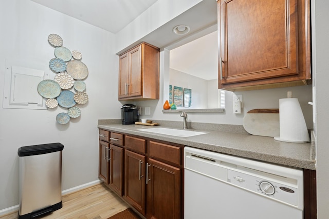 kitchen with dishwasher, sink, and light wood-type flooring