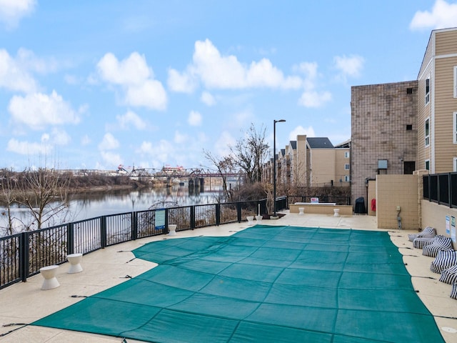 view of pool with a patio and a water view