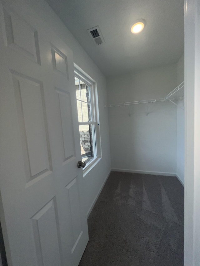 spacious closet featuring visible vents and dark carpet