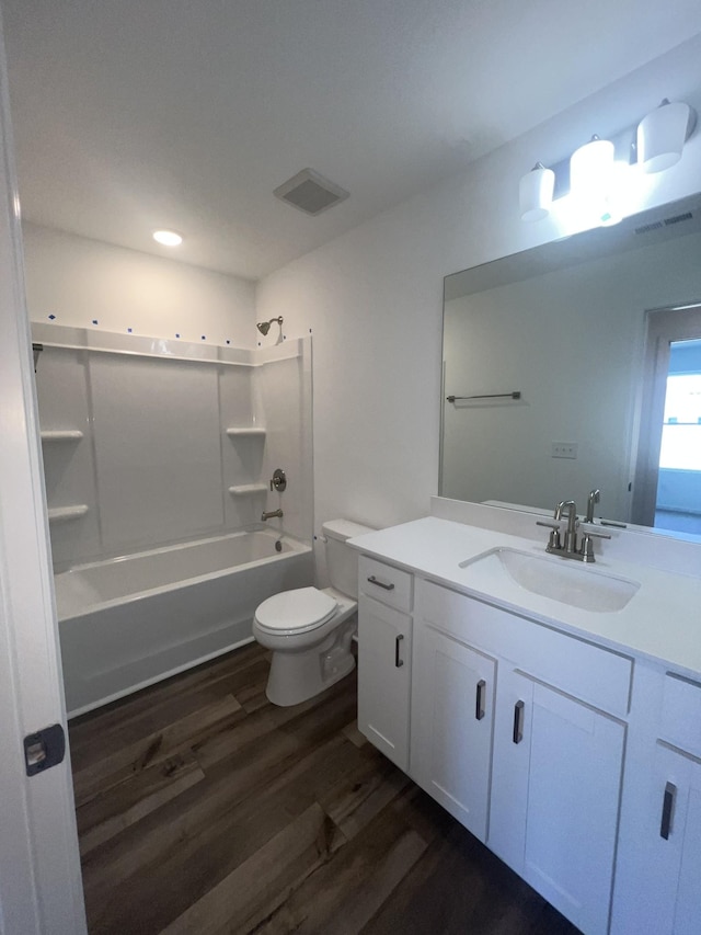 bathroom featuring visible vents, toilet, wood finished floors, tub / shower combination, and vanity