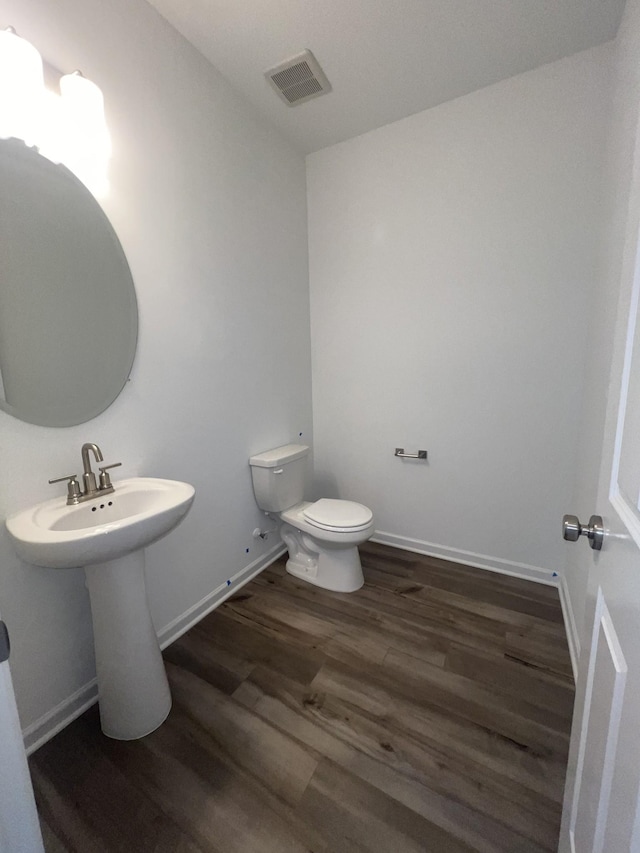 bathroom with visible vents, baseboards, toilet, and wood finished floors