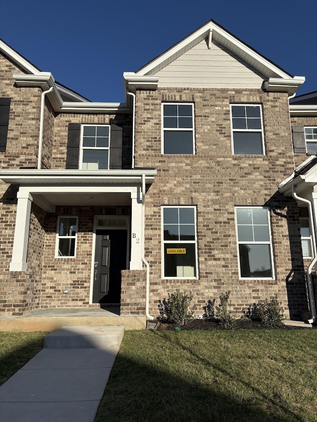 view of front of home featuring brick siding and a front lawn