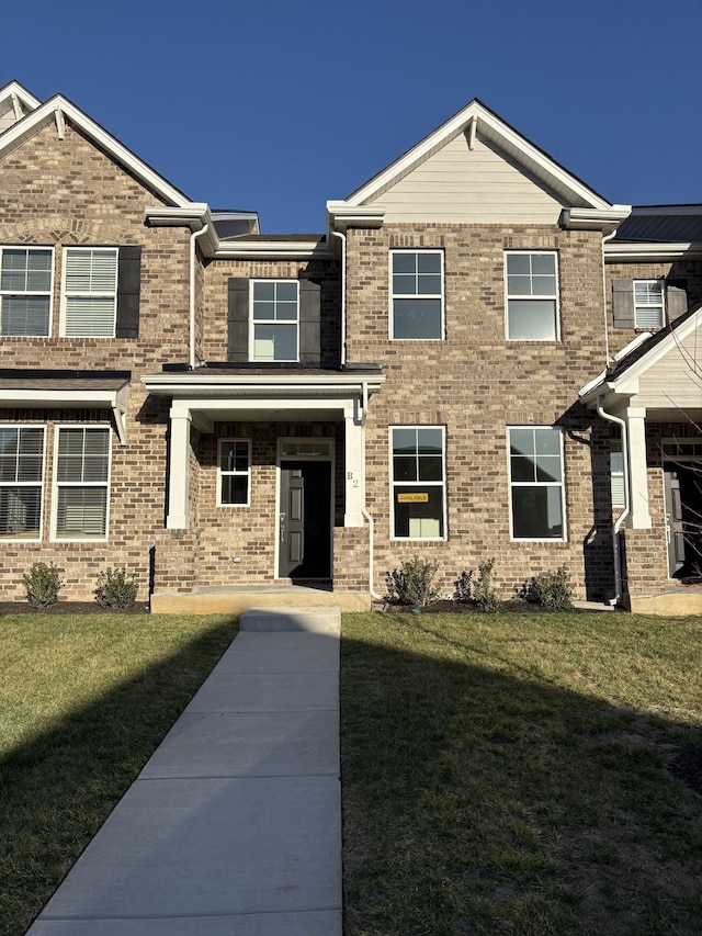 view of front of property featuring a front lawn and brick siding