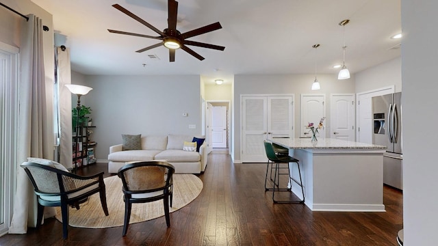 living room with dark wood-type flooring and ceiling fan