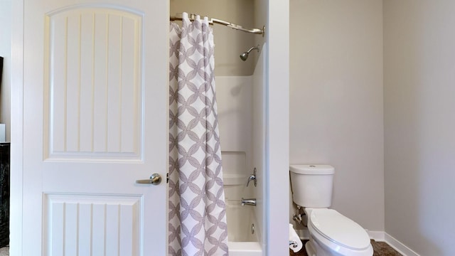 bathroom featuring shower / tub combo and toilet