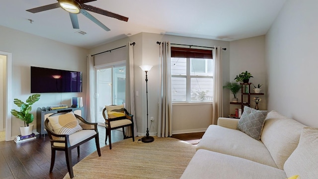 living room with dark wood-type flooring and ceiling fan