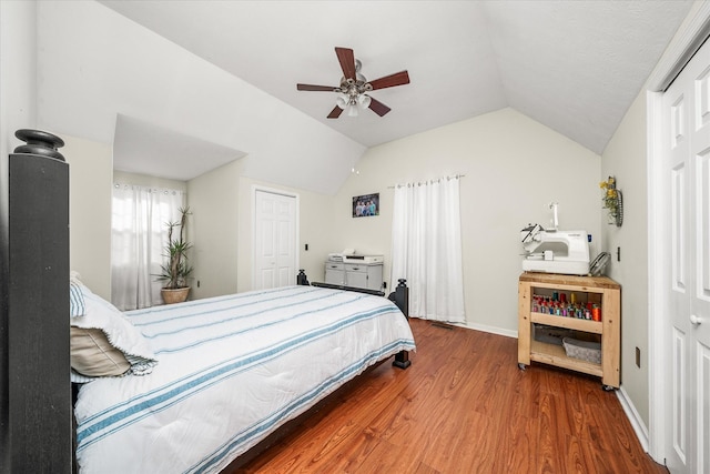 bedroom with lofted ceiling, hardwood / wood-style floors, a closet, and ceiling fan