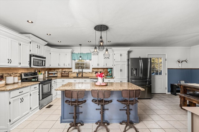 kitchen featuring appliances with stainless steel finishes, decorative light fixtures, a center island, and sink