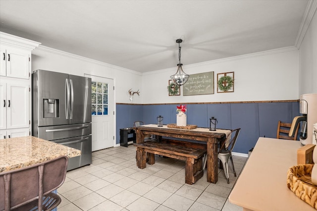 dining space featuring crown molding, an inviting chandelier, and light tile patterned floors