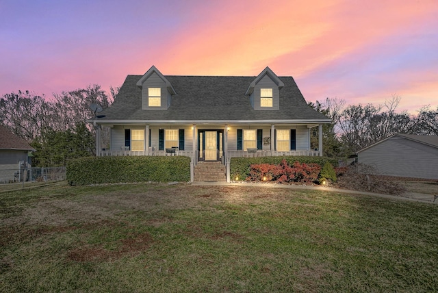 new england style home with a yard and a porch