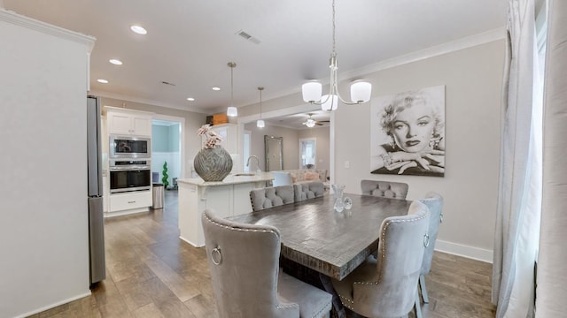 dining space with sink, ornamental molding, and dark hardwood / wood-style floors