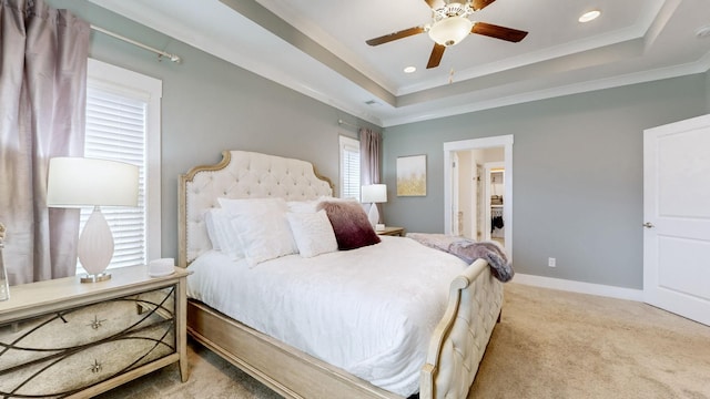 carpeted bedroom featuring crown molding and a tray ceiling