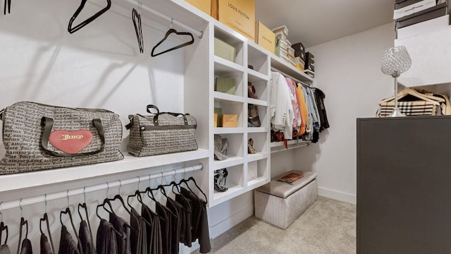 walk in closet featuring light colored carpet