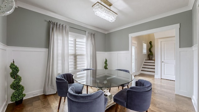 dining room featuring an inviting chandelier, crown molding, and hardwood / wood-style flooring