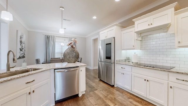 kitchen featuring sink, white cabinetry, appliances with stainless steel finishes, ornamental molding, and pendant lighting