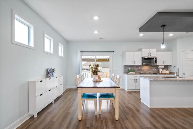 dining area with sink and dark wood-type flooring