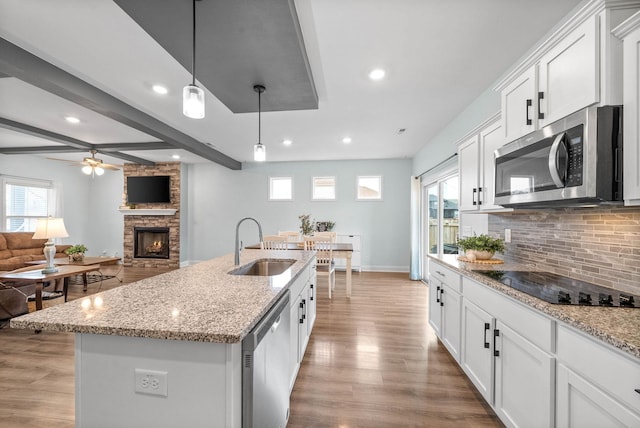 kitchen with sink, white cabinetry, an island with sink, pendant lighting, and stainless steel appliances