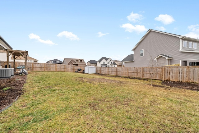 view of yard with central AC and a storage shed