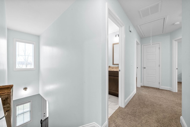 corridor featuring light colored carpet