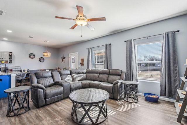 living room featuring ceiling fan, sink, hardwood / wood-style floors, and a wealth of natural light