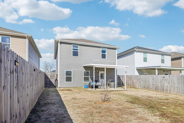 rear view of house with a patio and a lawn