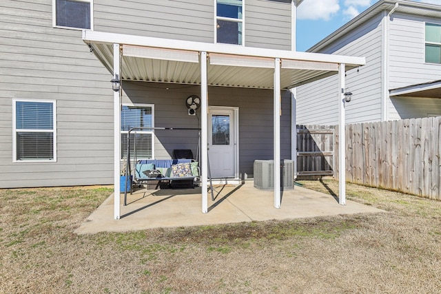 doorway to property with cooling unit, a lawn, and a patio