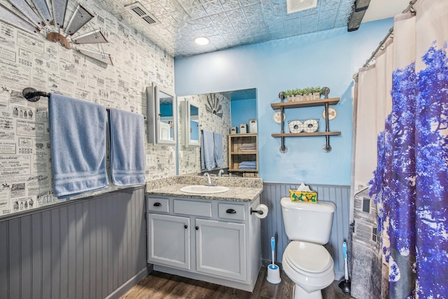 bathroom featuring hardwood / wood-style flooring, vanity, a shower with shower curtain, and toilet