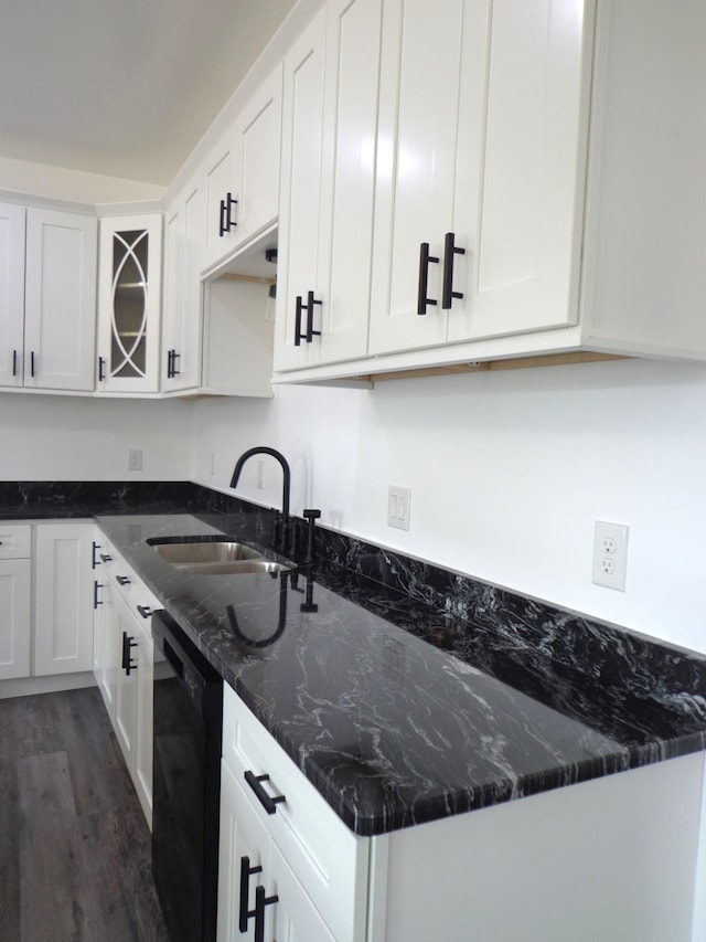 kitchen featuring sink, dark hardwood / wood-style floors, black dishwasher, white cabinets, and dark stone counters