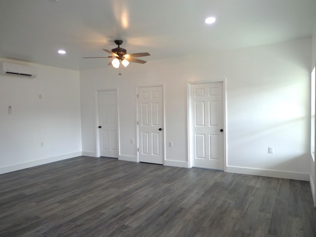 unfurnished room with dark wood-type flooring, a wall mounted air conditioner, and ceiling fan