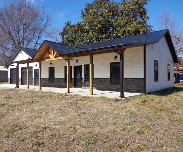 view of front of house with a garage, a patio, and a front yard