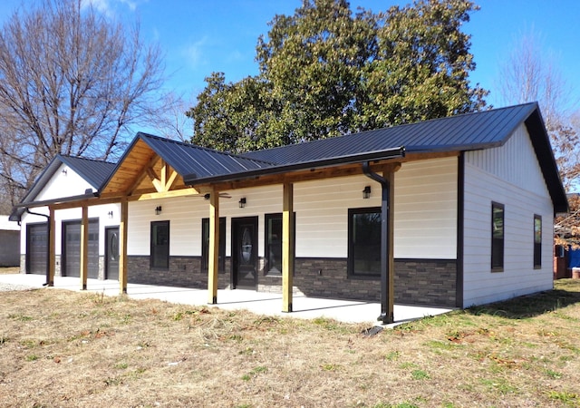 back of house with a garage, a patio area, and a lawn