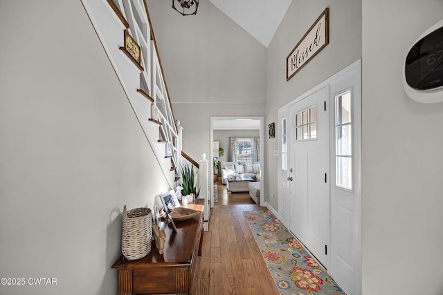 entryway with high vaulted ceiling and hardwood / wood-style floors