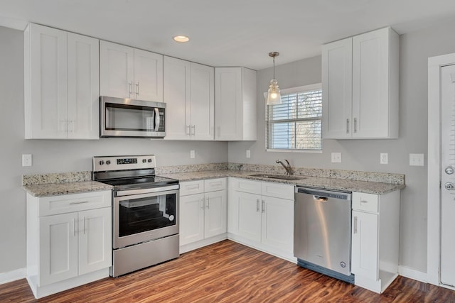 kitchen featuring white cabinetry, appliances with stainless steel finishes, sink, and hanging light fixtures