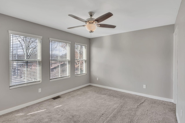 carpeted spare room featuring ceiling fan