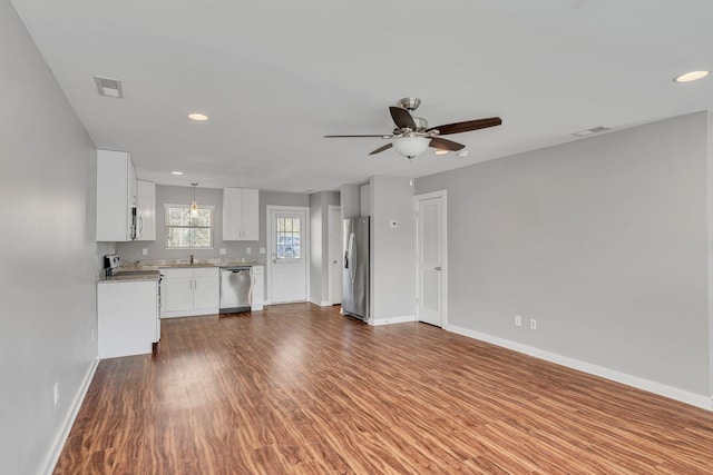 unfurnished living room featuring dark hardwood / wood-style floors, sink, and ceiling fan