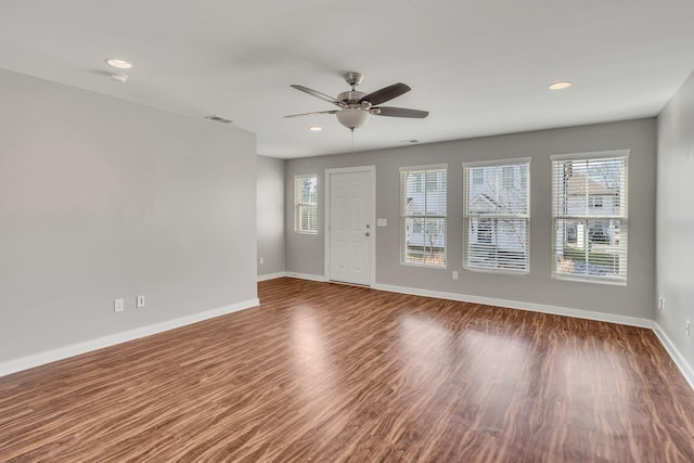 spare room with dark wood-type flooring and ceiling fan