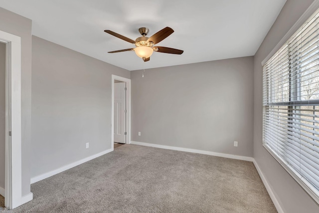 carpeted spare room featuring ceiling fan