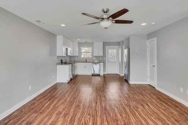 unfurnished living room featuring sink, dark hardwood / wood-style floors, and ceiling fan